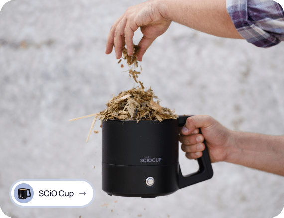 A person fills a SCiO Cup device with wood chips.